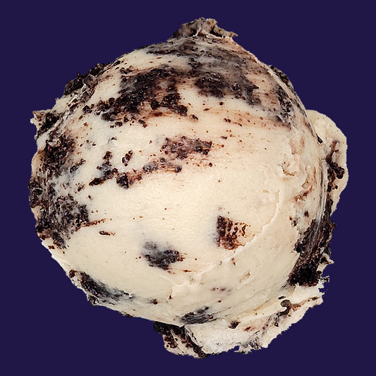 a scoop of Cookies & Cream non-dairy gelato, sweet cream off-white with crumbles of gluten-free black cocoa cookies against a dark navy background